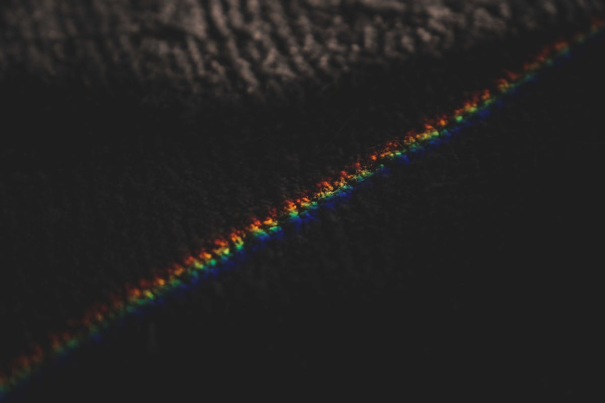 Reflets de lumière arc-en-ciel sur une surface, illustrant le test de couleurs en chromothérapie